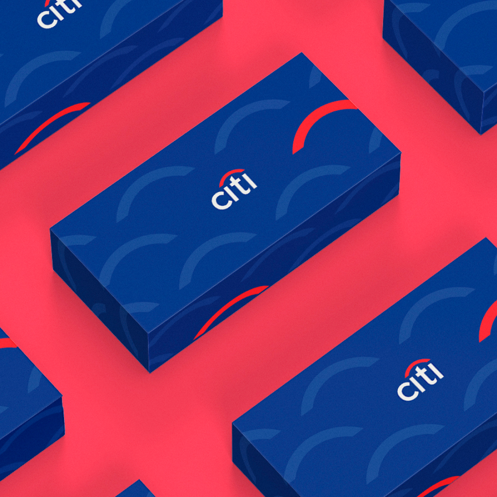 Design As A Service 7 Blue gift boxes with a pattern of semicircles and the word citi are arranged on a pink surface. Each box features a red arc above the brand name, showcasing an eye-catching design subscription style.