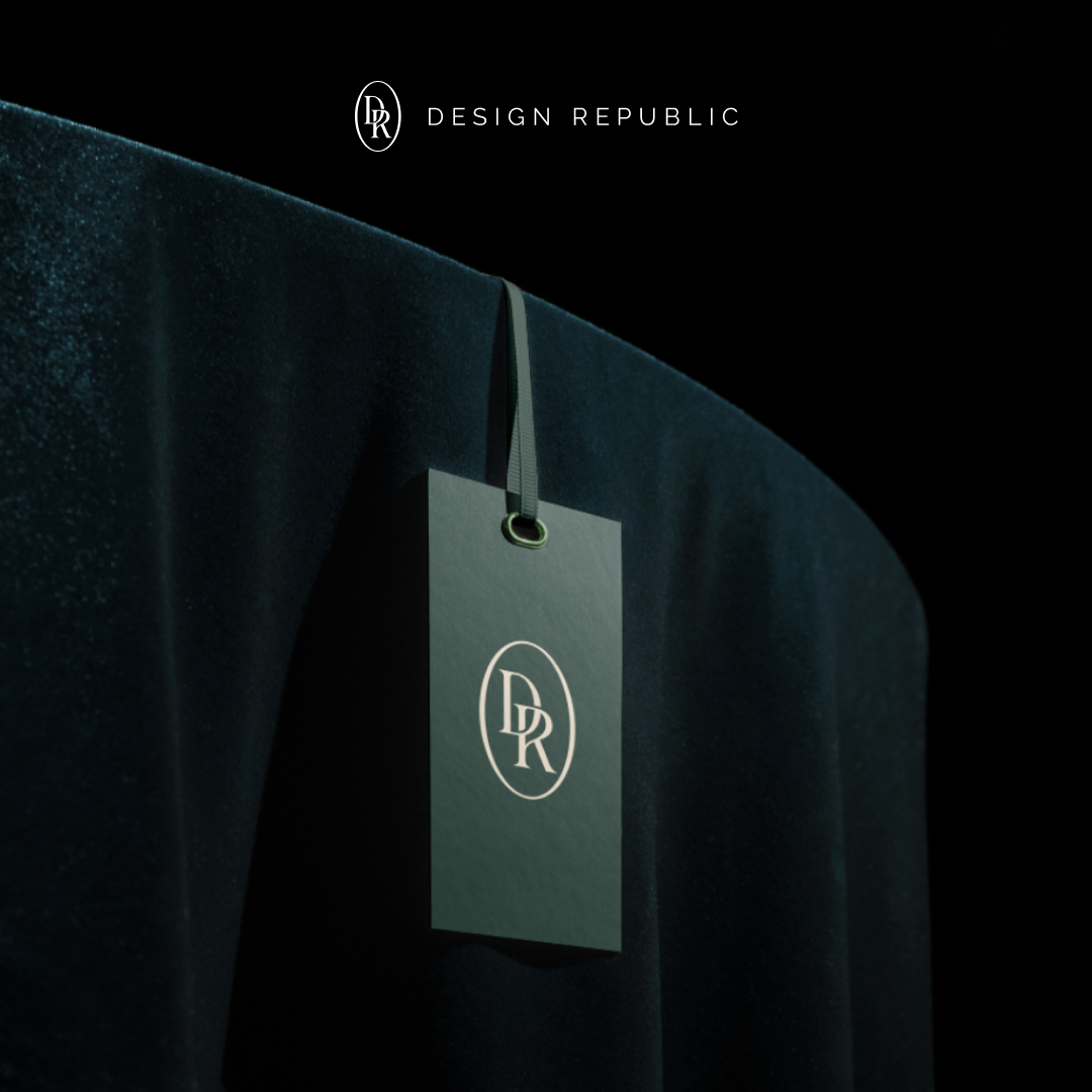 Design As A Service 8 A sleek black tag with the DR logo hangs on a luxurious dark green velvet fabric, symbolizing an exclusive design subscription. The text DESIGN REPUBLIC is elegantly displayed above in minimalist style, set against a dark background.